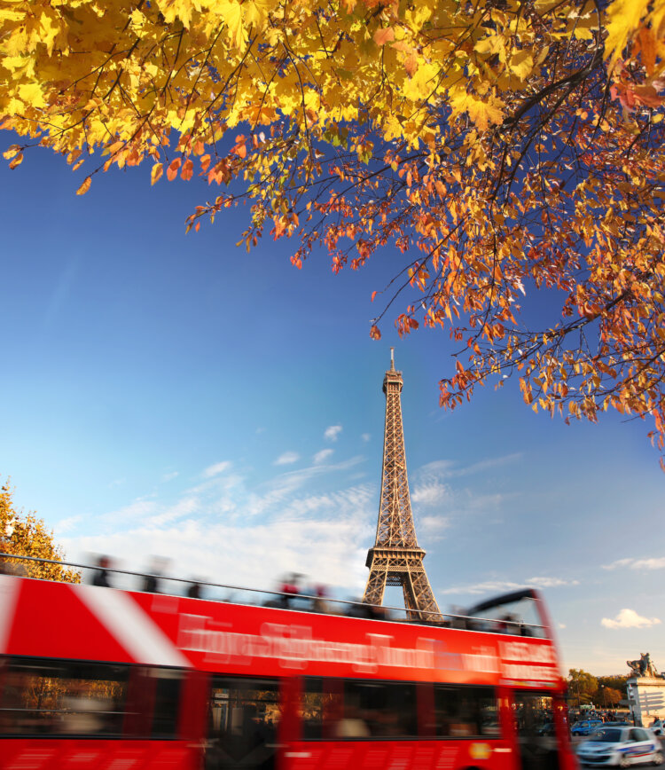 Eiffel Tower against tourist red bus in Paris, France