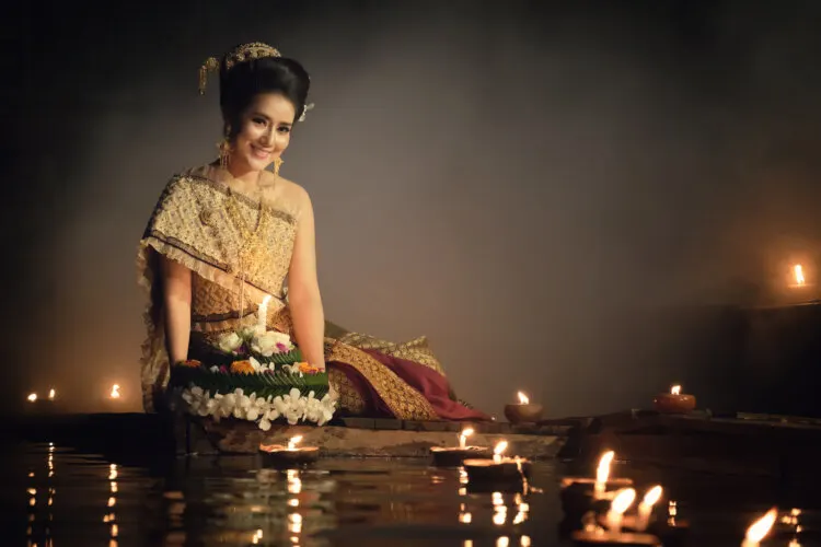 Thai woman in traditional dress hold kratong to float in Loi kratong day of Thailand
