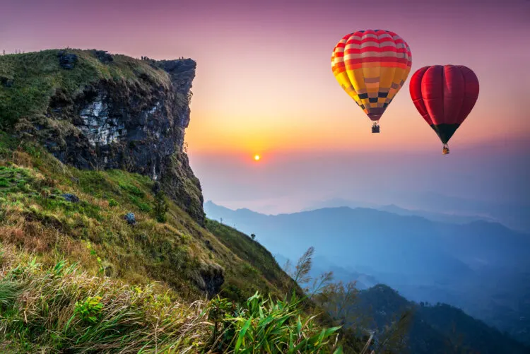Colorful hot air balloons flying over mountain at Phu Chi Thailand