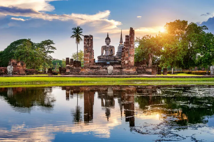 Buddha statue and Wat Mahathat Temple in the precinct of Sukhothai Historical Park