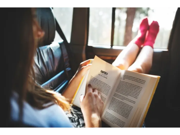 Woman reading book while traveling