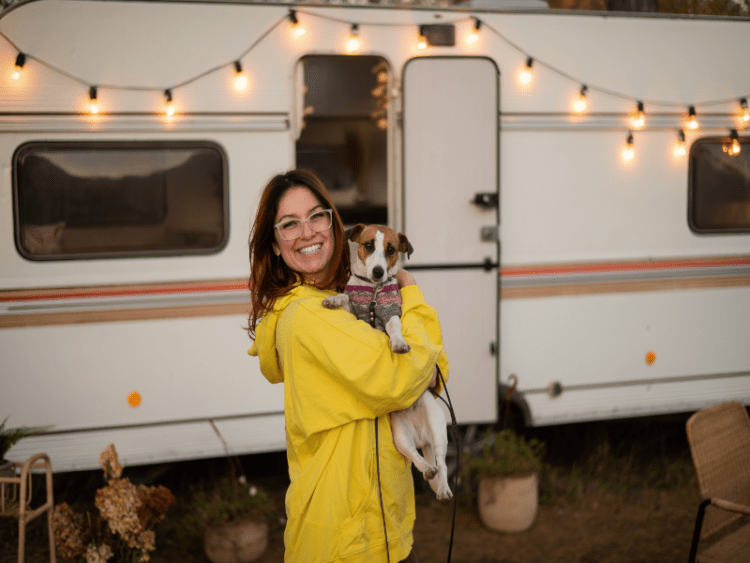 Woman hugs a dog and lives in motor home