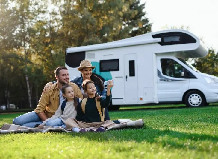 Happy young family with two children and a trailer