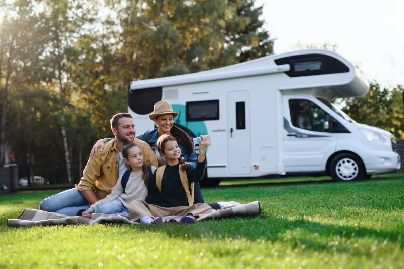 Happy young family with two children and a trailer
