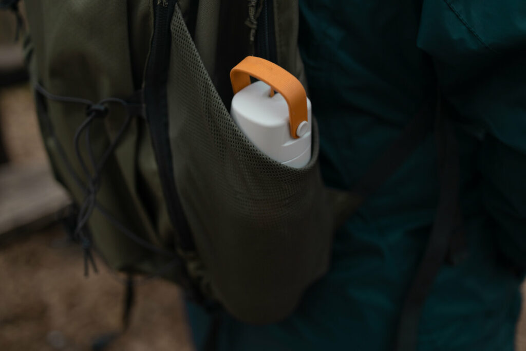 Close-up of a backpack pocket with a reusable water bottle