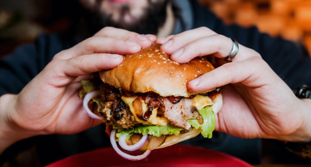 Man holding and ready to eat a cheeseburger