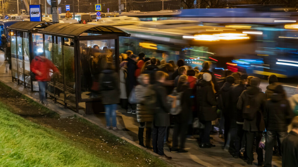 Crowd of passengers on a bus stop waiting for a bus