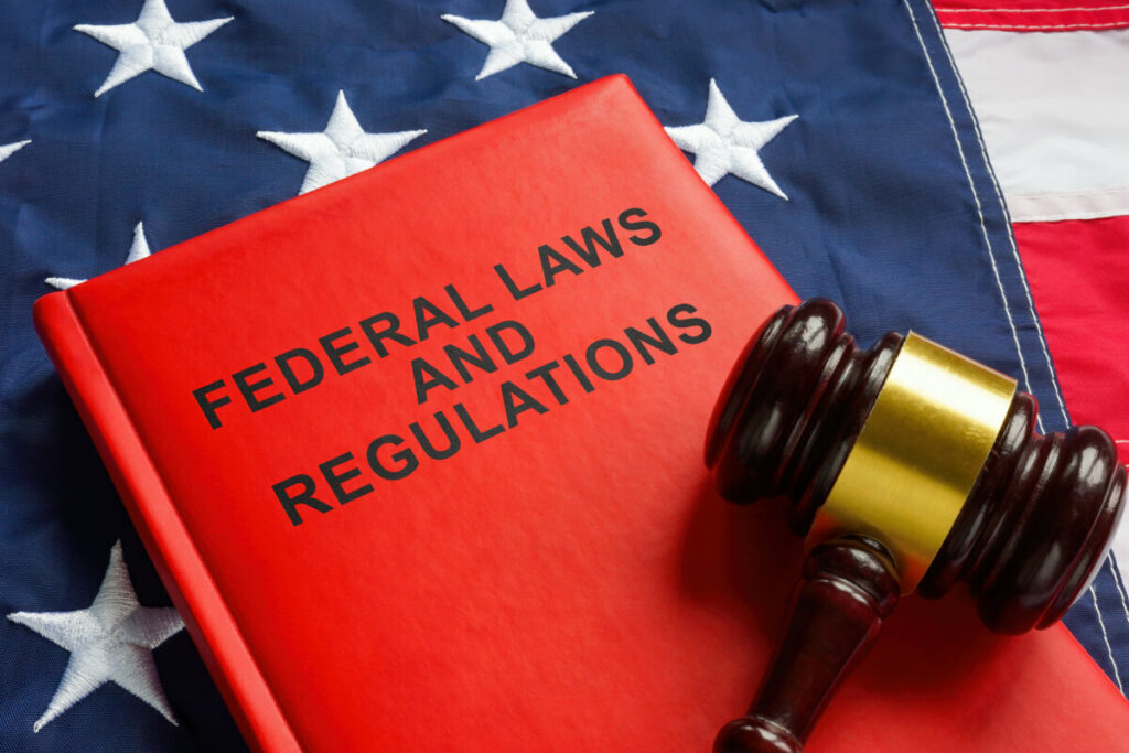 Close-up of the Federal laws and regulations book and gavel on top of the US Flag