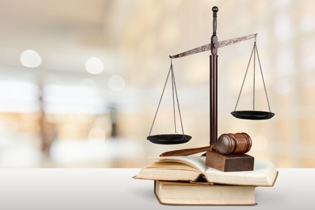 Close-up of a judge's gavel, law books, and scales of justice