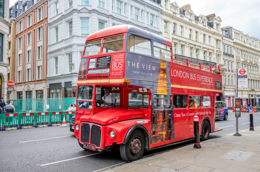 Red double decker open top tour bus in London, England