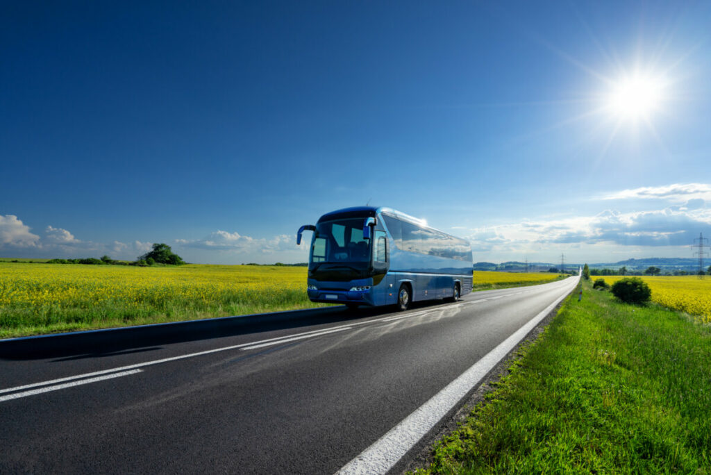 Blue bus  driving on a road during the day 