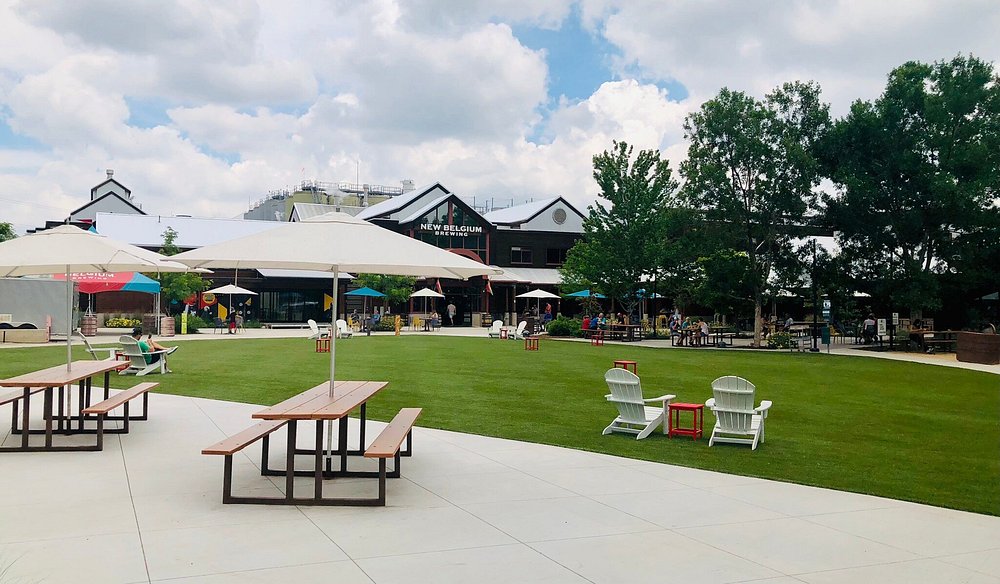 Relaxing outdoor space at New Belgium Brewing with picnic tables and vibrant seating options.