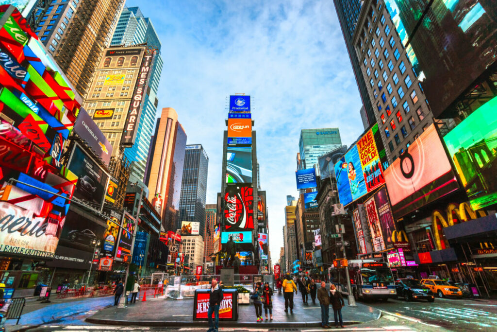 Panoramic view of the neon lights, billboards, crowds, and streets in Times Square, New York City