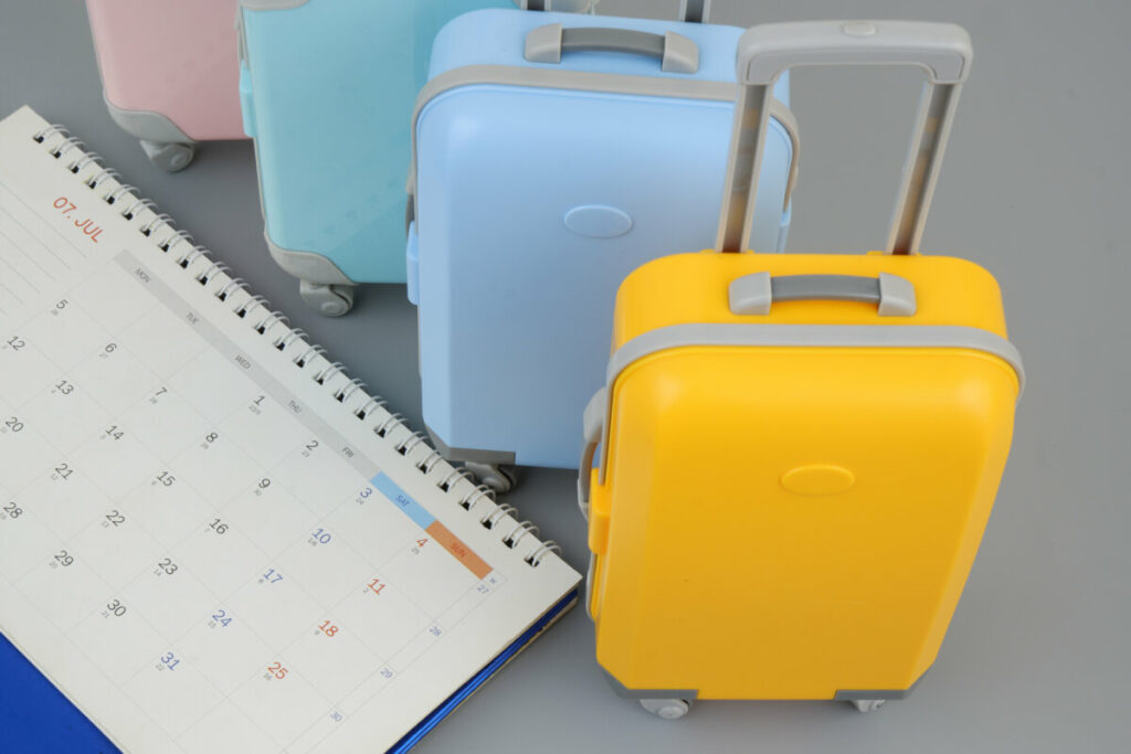 Calendar next to a suitcases for travel planning